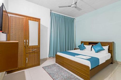 a bedroom with a bed with blue pillows and a mirror at SQUARE INN in Bengaluru