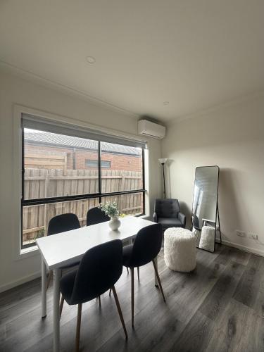 a living room with a table and chairs and a window at Peaceful Private Room in Wyndham Vale in Wyndham Vale