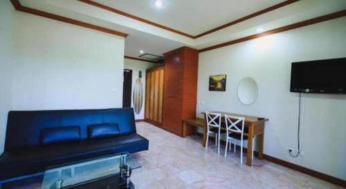 a living room with a couch and a flat screen tv at AmornSukhothai Hotel in Sukhothai