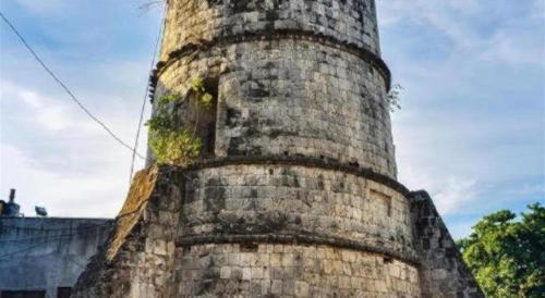 an old brick tower with moss growing on it at Dino Residences in Dumaguete