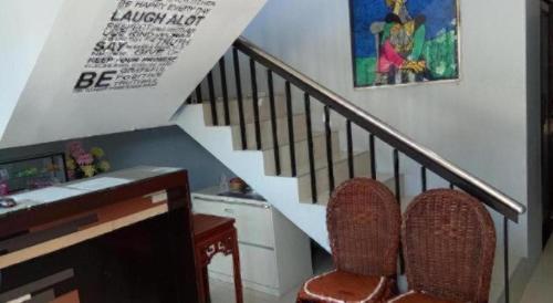 a staircase with two chairs and a desk and a stair case at Dino Residences in Dumaguete