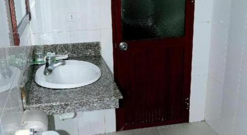 a bathroom with a sink and a red door at Hai Au Hotel in Hai Phong