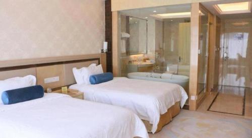 a hotel room with two beds and a bath tub at Shanghai Fuyue Hotel in Shanghai