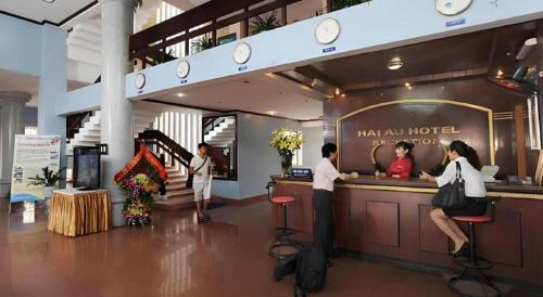 a group of people standing at a bar in a hotel at Hai Au Hotel in Hai Phong