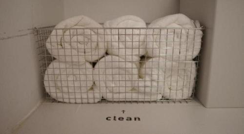 a basket filled with white towels in a room at SLEEEP HKG Causeway Bay in Hong Kong