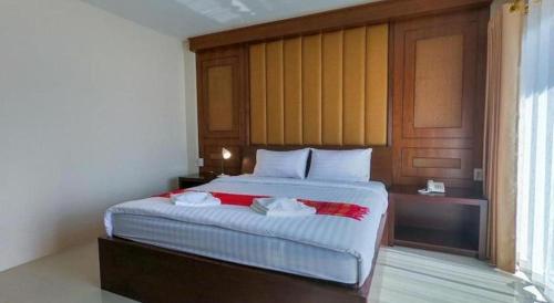 a bedroom with a bed with two towels on it at Bees Smile Hotel in Chiang Rai