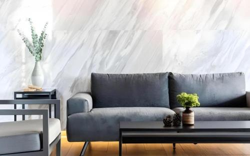 a living room with a blue couch and a table at XOTEL in Khon Kaen