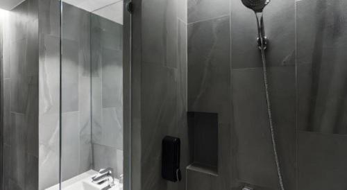 a shower in a bathroom with a sink at XOTEL in Khon Kaen