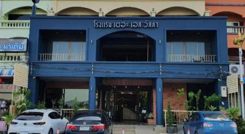 a blue building with cars parked in front of it at THE S VILLAS HOTEL in Nakhon Phanom