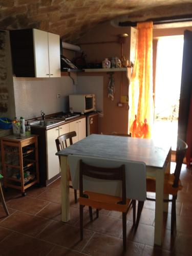 a kitchen with a table and a table and chairs at Casavacanze Ciaspole E Uva in Fiastra