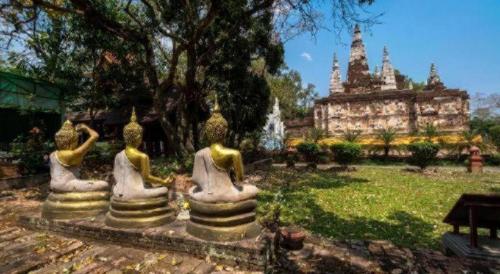 a group of statues in a park with a building at OYO 726 Sookjai Cafe and Hostel in Chiang Mai