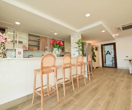 チェンカーンにあるChiangkhan Town Hotelのキッチン(バー、カウンターの椅子4脚付)