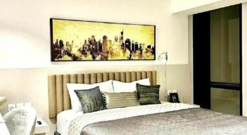 a bedroom with a bed with a painting above it at The Day Residence in Jakarta
