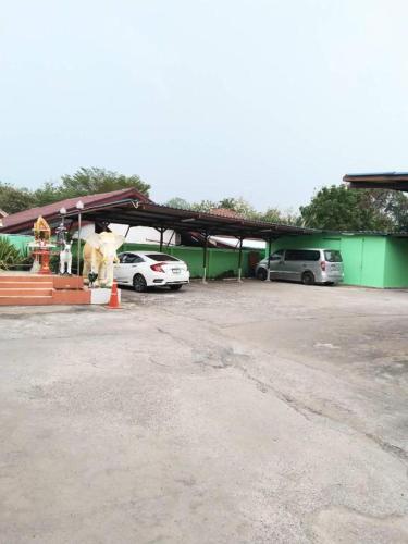 a parking lot with cars parked in front of a building at OYO 75399 Choktipparat Place in Udon Thani