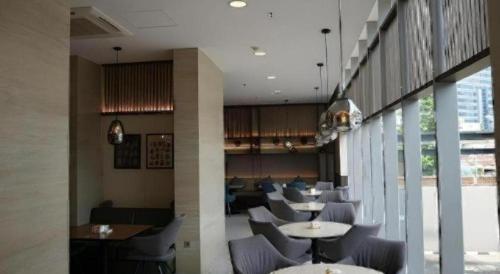 a restaurant with tables and chairs in a room at The Day Residence in Jakarta