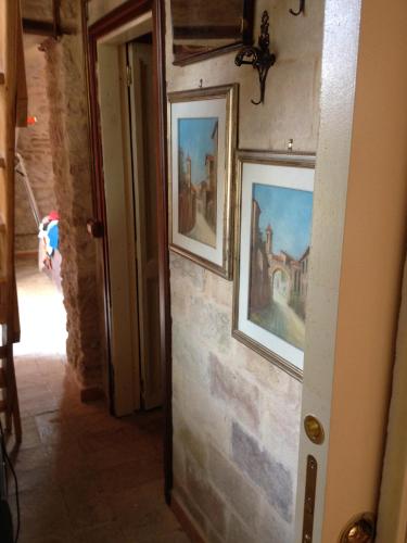 a hallway with two paintings on a stone wall at Casavacanze Ciaspole E Uva in Fiastra