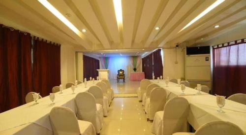 a banquet hall with white tables and white chairs at Marcian Business Hotel in Zamboanga