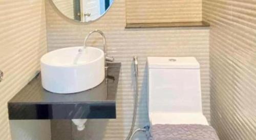 a bathroom with a sink and a toilet at The Hub Hotel Surin in Surin