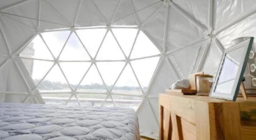 a bedroom with a tent with a bed and a window at Nornnadubua in Uthai Thani