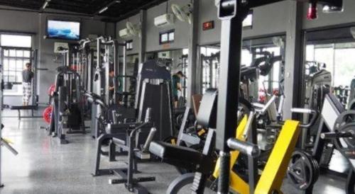 a gym with several rows of treadms and machines at The Hub Hotel Surin in Surin