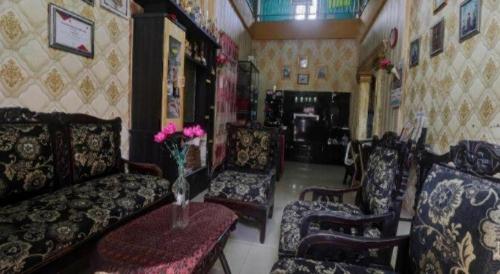 a living room with a couch and two chairs at Hotel O Rania Kost Simpang Rimbo in Jambi