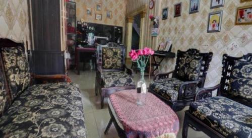 a living room with chairs and a vase of flowers on a table at Hotel O Rania Kost Simpang Rimbo in Jambi