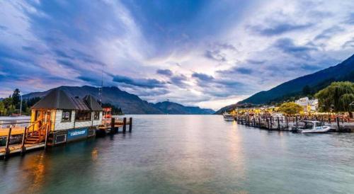 a large body of water with a dock with boats at Oaks Queenstown Club Suites in Queenstown
