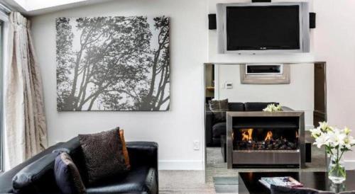 a living room with a fireplace and a tv at Oaks Queenstown Club Suites in Queenstown