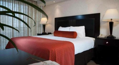 a hotel room with a large bed with a red blanket at El Tropicano Riverwalk in San Antonio
