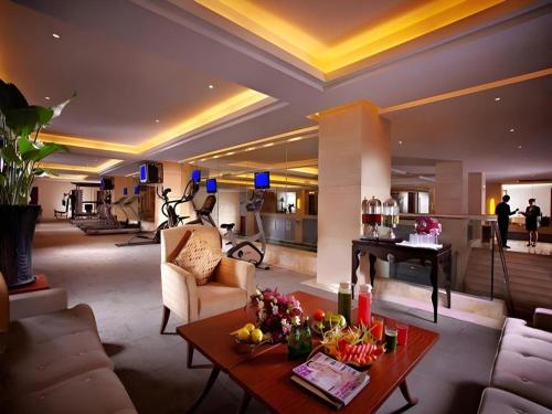 a living room with a table and a piano at New Century Hotel Taizhou 