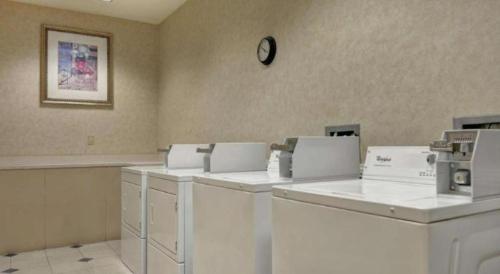a waiting room with white machines and a clock on the wall at Hilton Garden Inn Oshkosh in Oshkosh