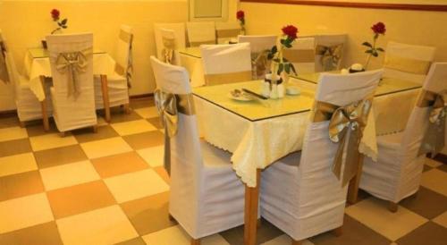 a dining room with white tables and chairs and a checkered floor at New Moon Hotel in Hanoi