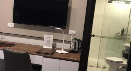 a room with a desk with a television and a laptop at New Moon Hotel in Hanoi