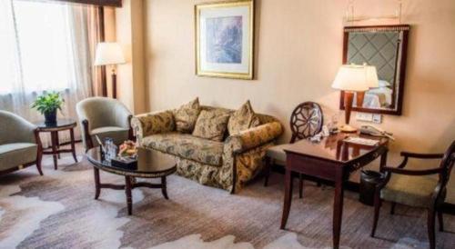 a living room with a couch and a table at New Century Hotel Taizhou 