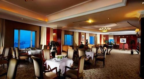 a restaurant with tables and chairs in a room at New Century Hotel Taizhou 