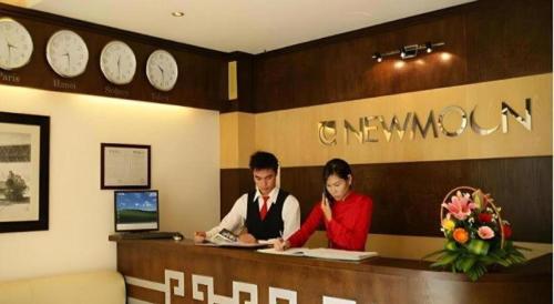 a man and woman sitting at a counter in a room at New Moon Hotel in Hanoi