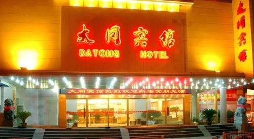 adqong noodle restaurant with a red sign on the building at Datong Hotel in Datong