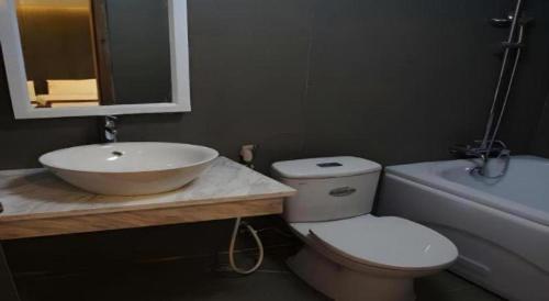 a bathroom with a toilet and a sink and a tub at New Moon Hotel in Hanoi