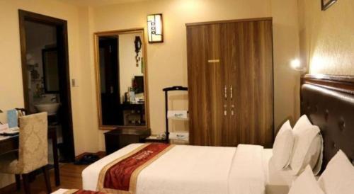 a hotel room with a bed and a desk and a room at New Moon Hotel in Hanoi