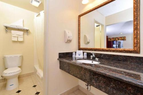 a bathroom with a sink and a toilet and a mirror at Americas Best Value Inn Redlands San Bernardino in Redlands