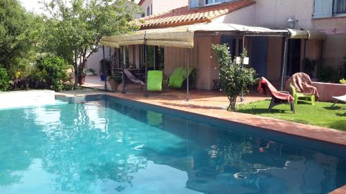 a swimming pool in a yard with chairs and a house at La Chambre De Salome in Collioure