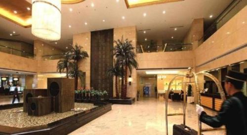 a man is walking through a shopping mall at Linyi Blue Horizon Intenational Hotel in Linyi