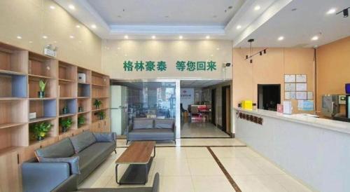 a lobby with couches and a table in a building at GreenTree Inn Taizhou New District Hospital of Renmin Hospital Mingliu Express Hotel in Jiuligou