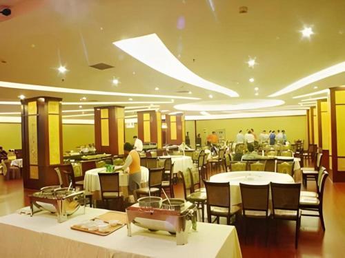 a restaurant with tables and chairs and people in it at New Friendship Hotel in Luoyang
