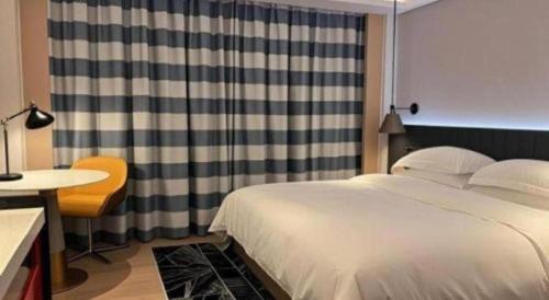 a bedroom with a bed and a desk and a table at Movie Star Hotel in Guangzhou