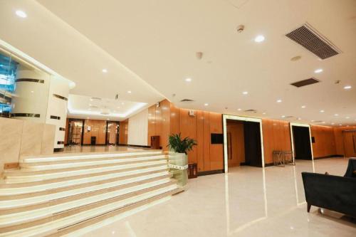 a lobby with a staircase in a building at Grand Soluxe Zhongyou Hotel Shenzhen in Shenzhen