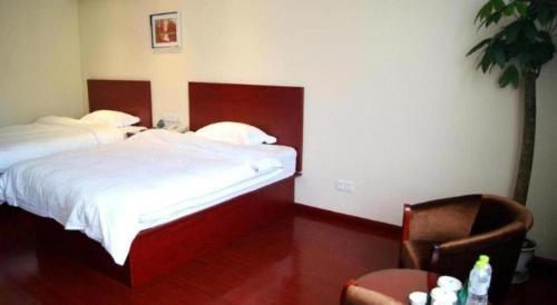 a hotel room with a bed and a chair at GreenTree Alliance Zhejiang Zhoushan Putuoshan Zhujiajian Scenic Spot Hotel in Zhoushan