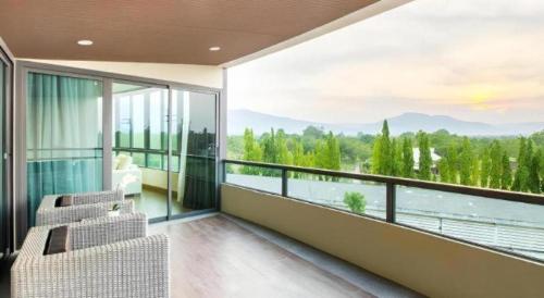 a room with a balcony with a view of the water at Green Valley Executive Serviced Residence in Chiang Mai