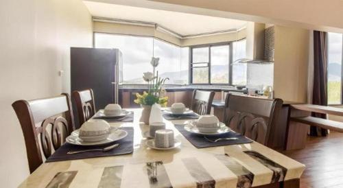 a dining room with a table and some chairs at Green Valley Executive Serviced Residence in Chiang Mai