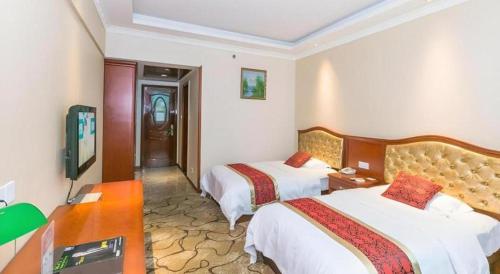 a hotel room with two beds and a television at GreenTree Alliance Zhejiang Zhoushan Putuoshan Zhujiajian Scenic Spot Hotel in Zhoushan